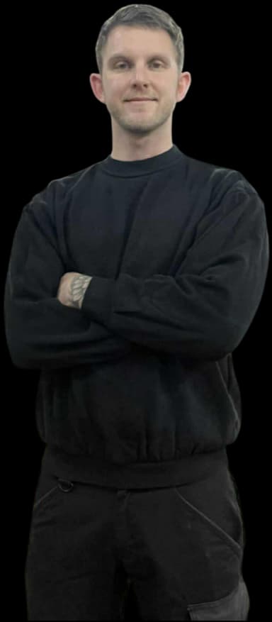 Ejer af værkstedet står med arme over kors